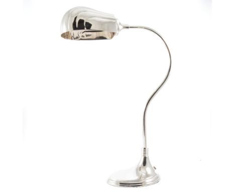 A modern nickel-plated desk lamp in the Art Deco style, the oval shell design shade on curved arm 53cm high supported on a st