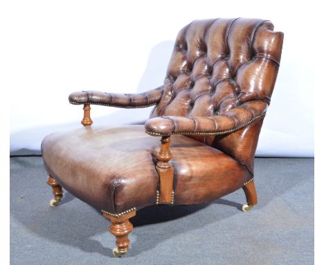 A Gentleman's  Edwardian salon armchair, re-upholstered in brown button back leather, turned legs to front with ceramic casto