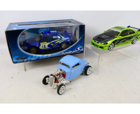 Solido - Ertl - Hot Wheels - 3 x cars in 1:18 scale, a boxed Subaru Impreza WRC # 9036 which appears to have had a battery li