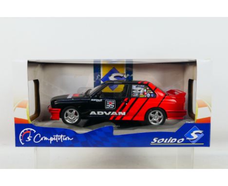 Solido - A boxed BMW E30 M3 in Advan racing livery in 1:18 scale # S1801521. The car appears Mint in a Good box with light st