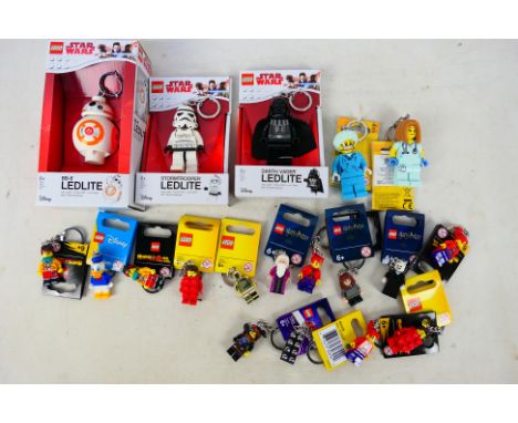 Lego - A collection of 20 Lego key chains and key lights. Lot includes #854198 Dumbledore Key Chain; #854111 Donald Duck Key 