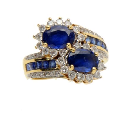 A SAPPHIRE AND DIAMOND CLUSTER CROSSOVER RING, LATE 20TH C in gold, marked 750, size L ++In satisfactory second hand conditio