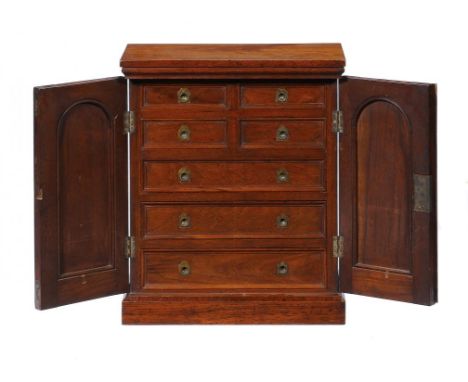 A VICTORIAN OAK COLLECTOR'S CABINET fitted with four short and three long moulded, graduated drawers with flush brass ring pu