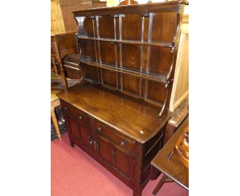 An Ercol dark elm dining suite, comprising; a dropflap table, set of six barback chairs, and a dresser (8)