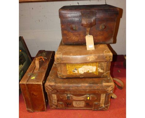 An Edwardian leather trunk, with old shipping label and end carry handles, w.93cm; together with three other smaller leather 