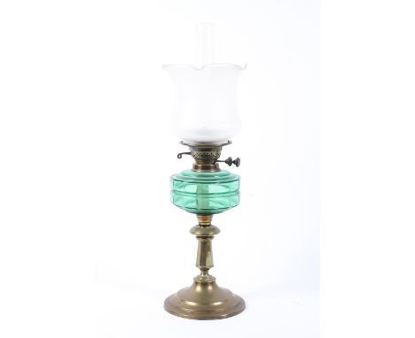 An Edwardian brass mounted oil lamp, with etched clear flared shade and green glass resevoir, with Duplex burner, on brass co
