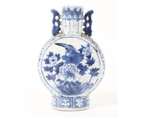 A Chinese Qing dynasty blue and white moon flask decorated with birds and peony flowers, with pierced handles to the shoulder