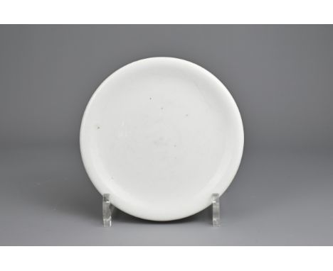 A CHINESE WHITE GLAZED PORCELAIN DISH, 17/18TH CENTURY. An almost flat circular dish on bi disc type foot, covered in a white