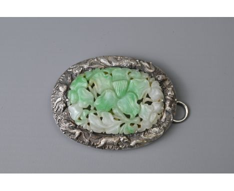 A CHINESE SILVER MOUNTED JADE CLIP BROOCH, EARLY 20TH CENTURY. Celadon and white jade carved and pierced into floral scrolls 