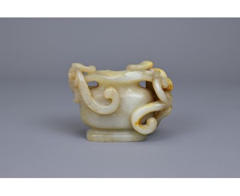 A CHINESE CARVED JADE WATER POT. Of yellowish green tone with areas of russet with two openwork figures of chilong climbing a