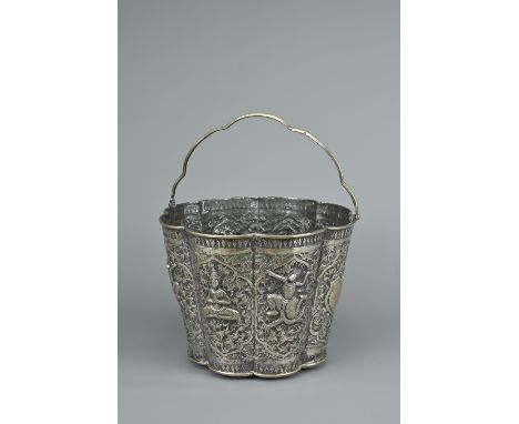 A SILVER REPOUSSE BUCKET, THAI MARKET, EARLY 20TH CENTURY. Of octagonal lobed form with handle decorated with figures of Thai