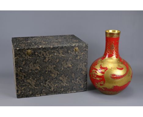 A VINTAGE CHINESE RED-GROUND DRAGON BOTTLE VASE IN BOX. Boldly decorated in gilding with a scrolling five-clawed dragon chasi