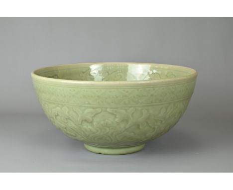 A LARGE CHINESE LONGQUAN TYPE CELADON BOWL. Heavily potted with rounded sides on short tapered foot with moulded leafy chrysa