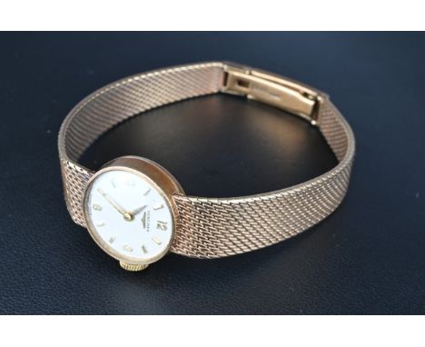 A LADIES 9KT GOLD LONGINES WRIST WATCH. With silver dial and mesh strap, manual wind, the clasp stamped DS&S 9 375Some surfac