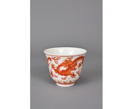 A CHINESE IRON-RED DECORATED PORCELAIN DRAGON CUP, GUANGXU MARK. Of bell shaped form with two dragons chasing flaming pearls 