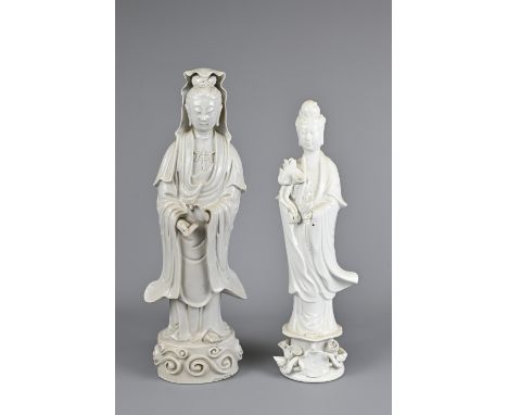 TWO CHINESE BLANC DE CHINE PORCELAIN FIGURES OF GUANYIN, 19/20TH CENTURY. Both figures standing dressed in robes holding a fl