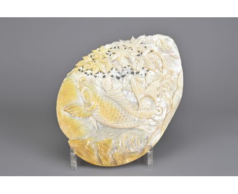 A LARGE CARVED MOTHER OF PEARL SHELL, PROBABLY JAPANESE EARLY 20TH CENTURY. The shell carved in relief with a carp leaping up