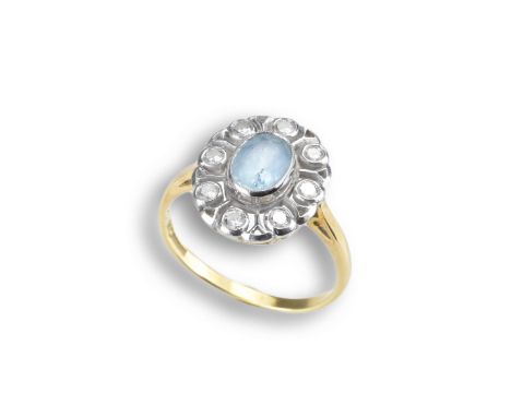 AN ANTIQUE 18CT GOLD AQUAMARINE DIAMOND CLUSTER RING. Central faceted aquamarine cabochon surrounded by eight diamonds in whi