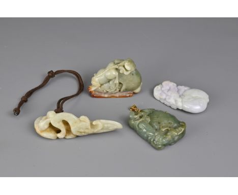 A GROUP OF FOUR CHINESE JADE ITEMS. To include a pale celadon openwork carved pendant in the form of a chilong on linzgi grou