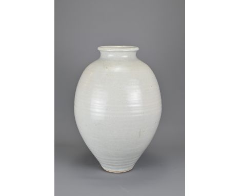 A WHITE GLAZED CERAMIC VASE, 20TH CENTURY. Heavily potted ovoid form with short neck and rolled rim with horizontal ribbed li