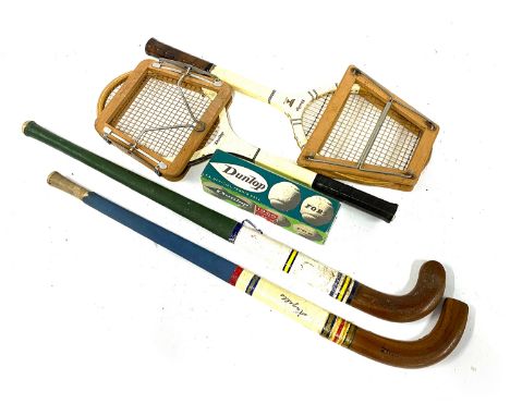 Two vintage tennis rackets with wooden presses, together with two vintage hockey sticks and 4 vintage tennis balls, boxed 