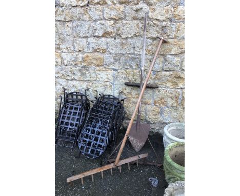 A mixed lot of vintage gardening tools; a large wooden rake, three pronged metal instrument, and spade 
