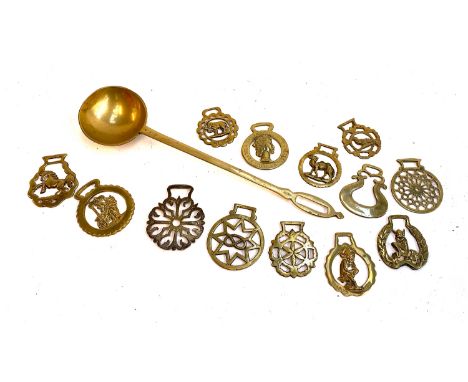 A quantity of horse brass together with an antique brass ladle 