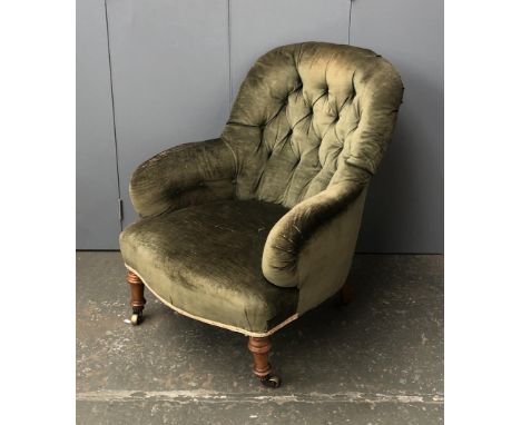 A Victorian button back armchair, on turned front legs with brass casters 