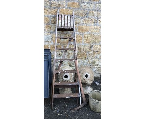 A vintage wooden seven rung stepladder, together with a vintage pickaxe 