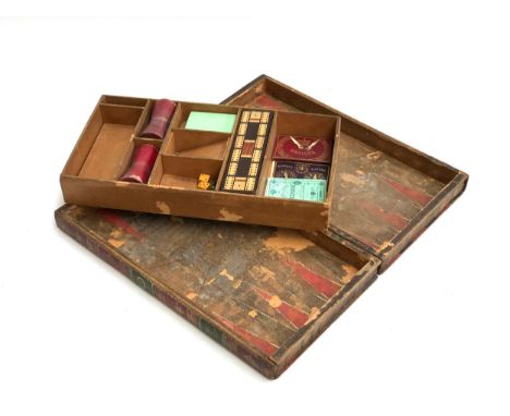 A leather games compendium, modelled as two leather bound volumes, comprising chess board, backgammon, besique, pieces missin