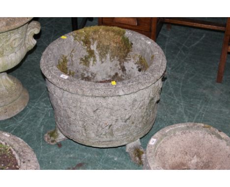 A reconstituted stone garden planter decorated with cherubs and raised on hairy paw feet, height 47 cm