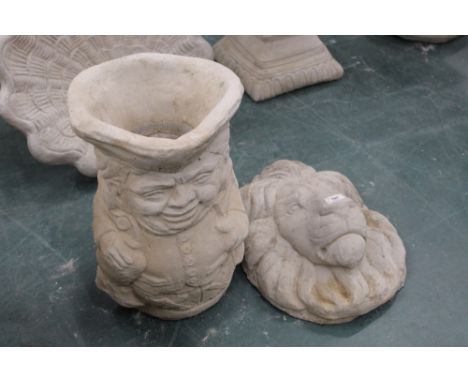 A concrete garden planter in the form of a Toby jug and a lion mask 