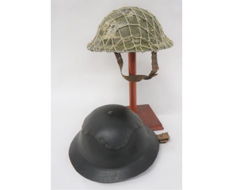 Two British WW2 Helmetsconsisting khaki, overpainted white example.  Black treated linen liner.  The fibre frame dated 1939. 