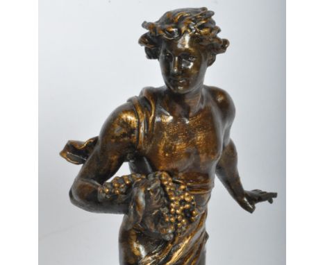 A vintage 20th century bronzed metal figure in the form of Bacchus who is depicted robed and holding grapes upon a naturalist