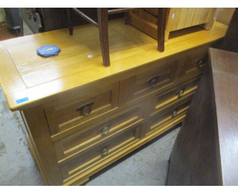 A contemporary light wood side cabinet of seven drawers with brass ring handles on bracket feet, 84 x 139.5 x 53cm and a ligh