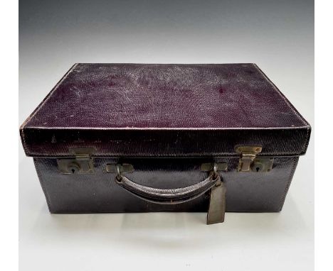 A purple leather toilet case by Mappin and Webb, the purple silk interior with silver-mounted fittings hallmarked London 1916