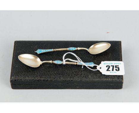 A cased pair of Norwegian silver gilt spoons with small bowls and decorative blue enamel filigree and twist handles, total 0.