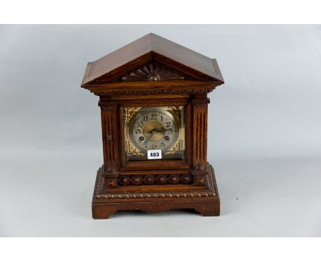 An Edwardian oak cased mantel clock, a classical style case in the architectural style with various styles of carving and mou