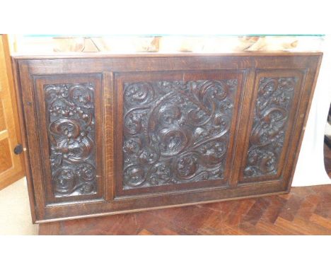 Three 19th century continental oak carved panels in later frame forming an over-mantel frieze Condition reports are not avail