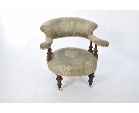 A Victorian walnut upholstered tub chairThe padded back and out swept arms supported on four fluted baluster spindles above a