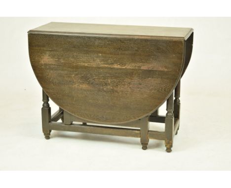 A 19th Century oval oak drop-leaf supper tableRaised on ring turned tapering supports, plain cross stretchers and bun feet, 1