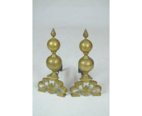 A pair of Victorian brass and ironsThe double spherical sides, with flame finial, raised on pierced bracket fronts, supported