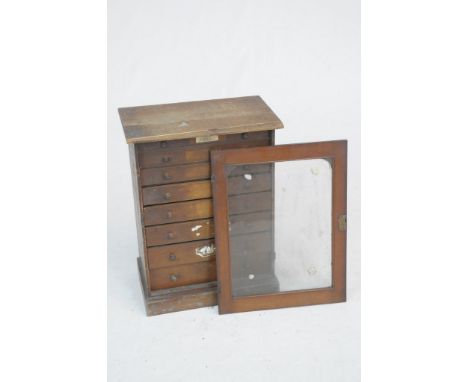  A Victorian stained pine specimen chestThe hinged glazed front (detached) enclosing seven drawers each with button handles u