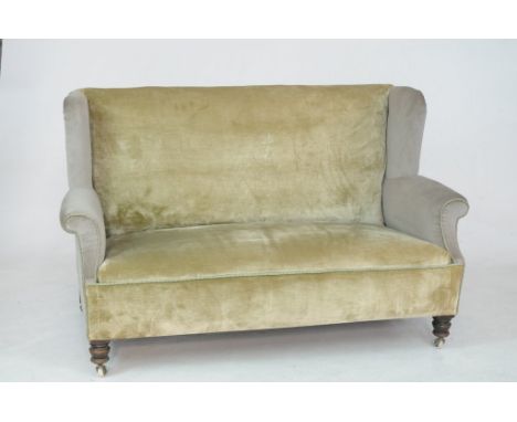 A late Victorian upholstered two seater wing back setteeWith padded outswept scroll arms and covered in green velour with rop