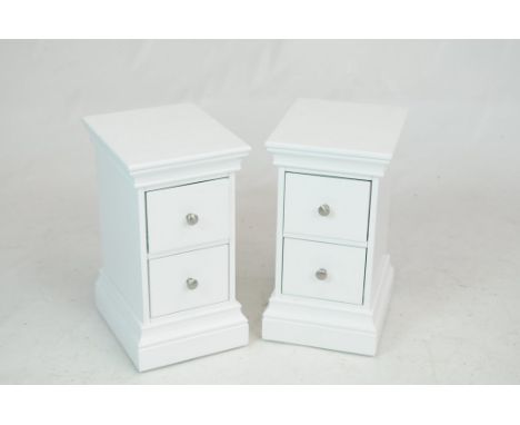 A pair of modern white bedside chestsEach with a rectangular moulded top above two drawers each with brush metal button handl