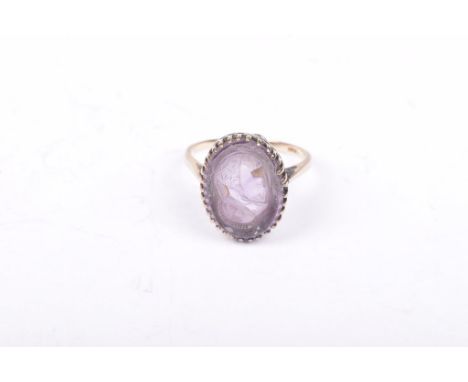 A 9ct gold an amethyst cameo ringThe oval carved amethyst, depicting the profile of a solider, to a yellow metal mount stampe