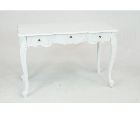 A painted French style side tableWith a shaped moulded top above three frieze drawers each with metal button handles raised o