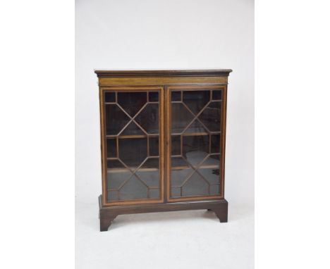 An Edwardian inlaid mahogany display cabinetThe rectangular moulded and cross banded top above a similarly cross banded friez