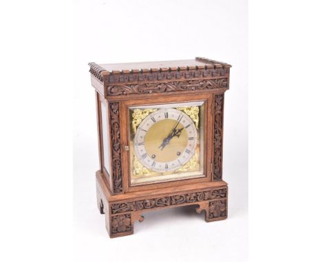 An early 20th Century carved oak cased 8-day mantel clockThe carved architectural case with square glazed door, housing silve