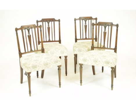 A set of four mahogany Regency dining chairsThe chairs with a Prince of Wales feathers motif above a fluted vases shaped cent